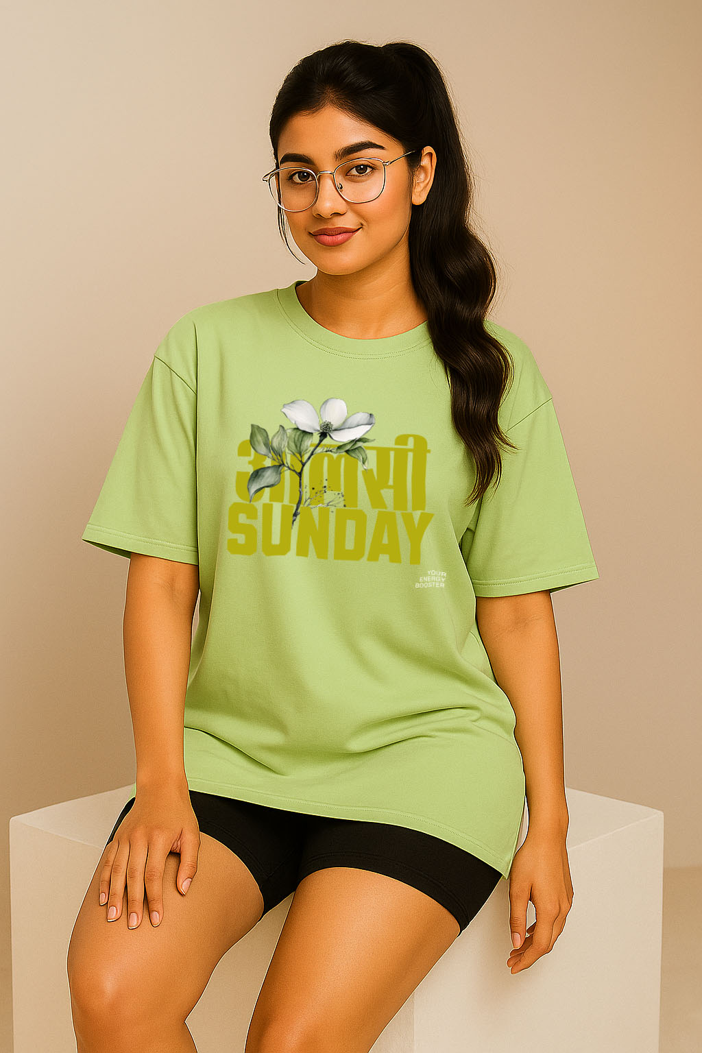 Woman seated wearing BANKAZ green oversized t-shirt with Hindi Sunday print – casual fashion
