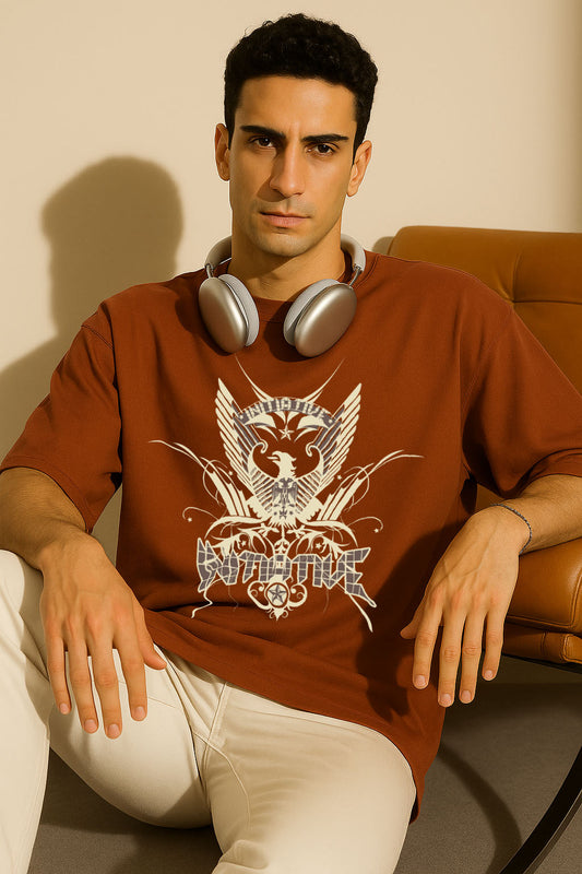 Sitting pose wearing BANKAZ brown oversized t shirt with eagle emblem graphic on front