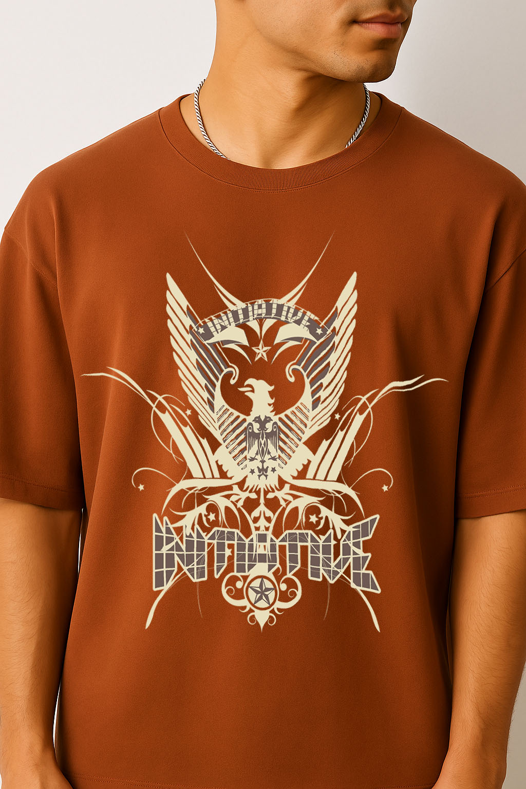 Close-up of eagle emblem graphic on BANKAZ brown oversized t shirt