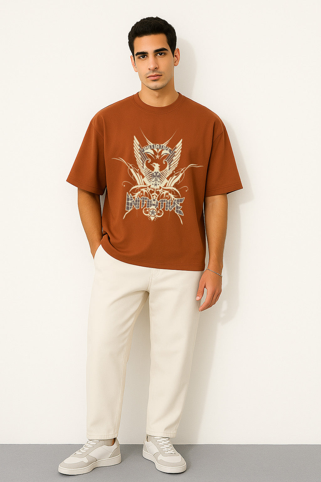Full front view of BANKAZ brown oversized eagle emblem t shirt styled with light trousers