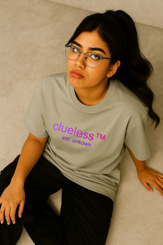 Sitting model wearing grey oversized tee with simple neon purple print – women’s casual streetwear