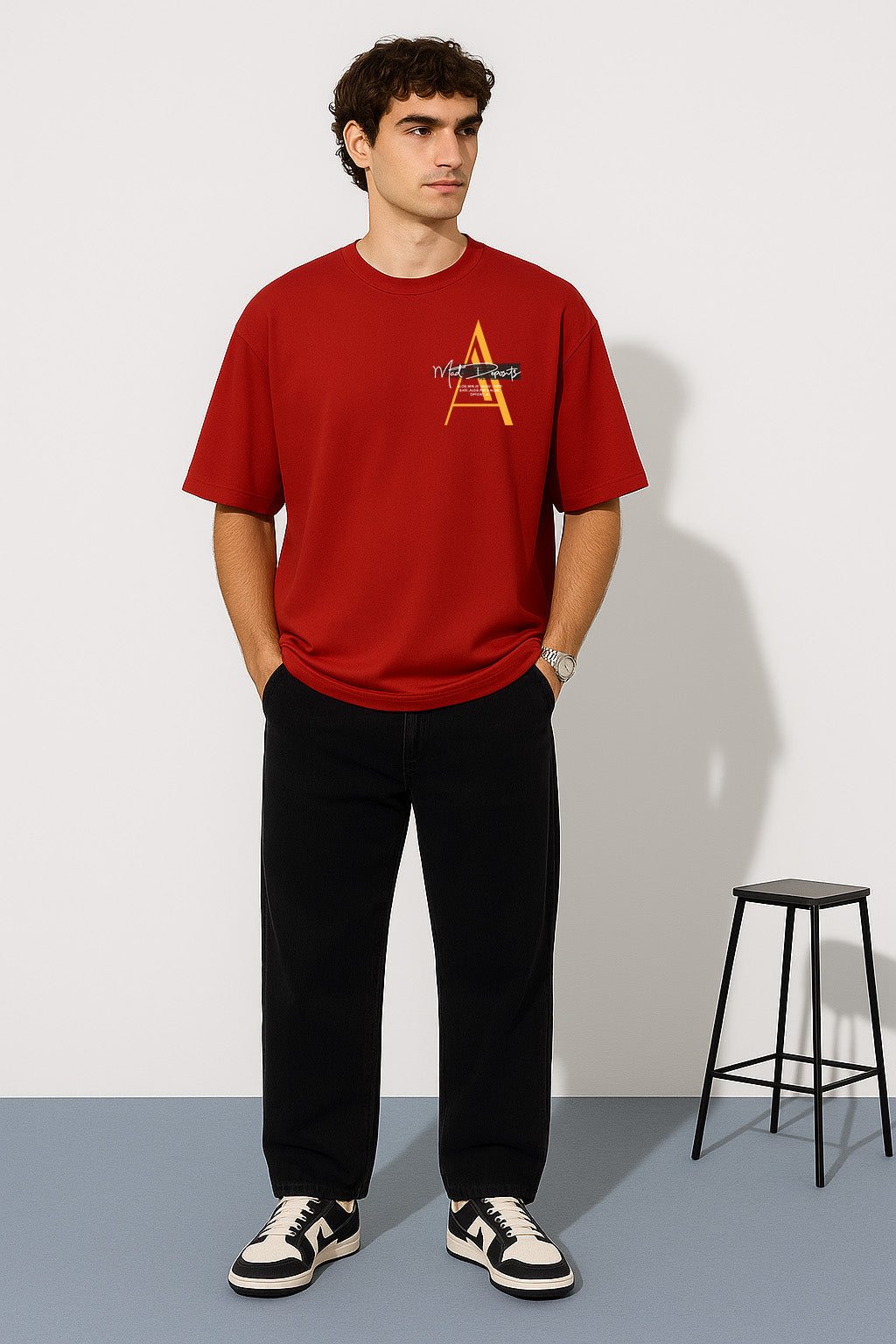 Front view of red oversized t shirt with subtle lone wolf chest graphic and bold A monogram design