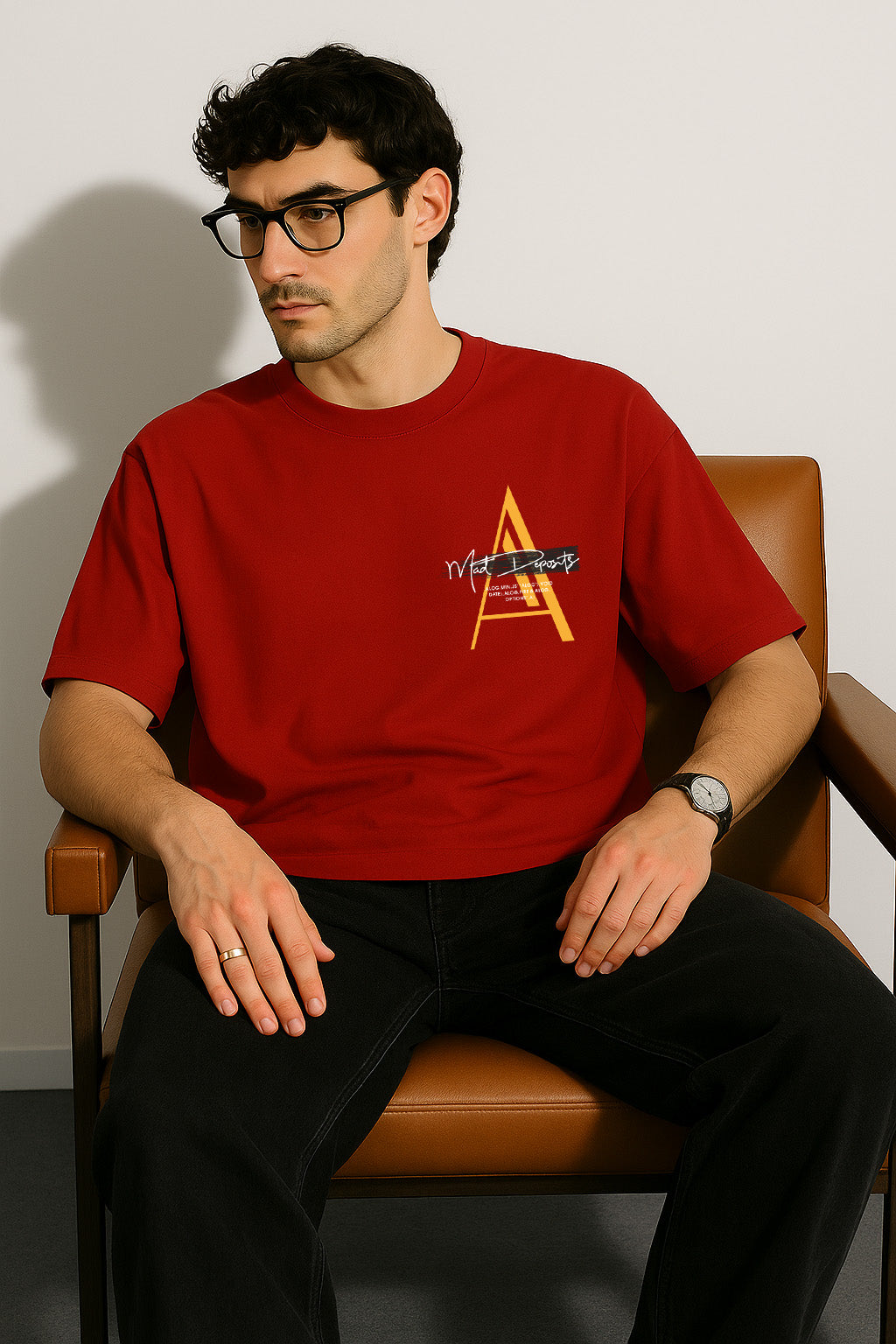 Seated view of red oversized t shirt styled with lone wolf theme and front printed chest monogram