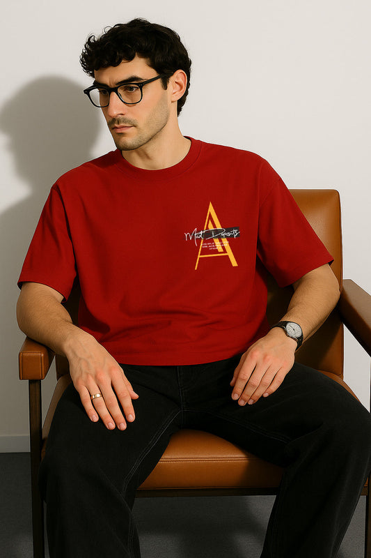 Seated view of red oversized t shirt styled with lone wolf theme and front printed chest monogram