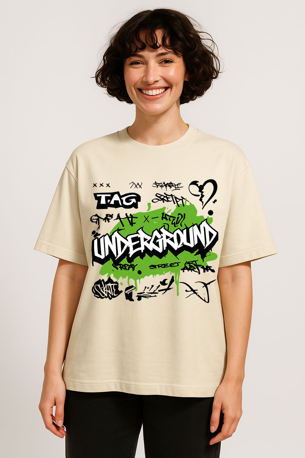Front view of off-white oversized cotton t-shirt for women with bold underground graffiti text in green