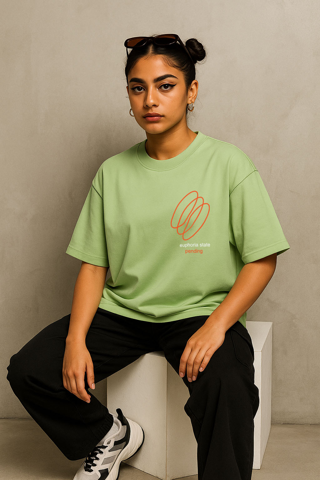 Front seated view of green oversized t-shirt for women with minimal Euphoria chest print